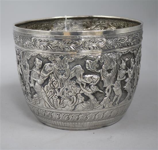 A Burmese large white metal bowl, embossed with bands of dancing figures, foliage, etc. 24.5oz h. 15cm, d. 19.7cm